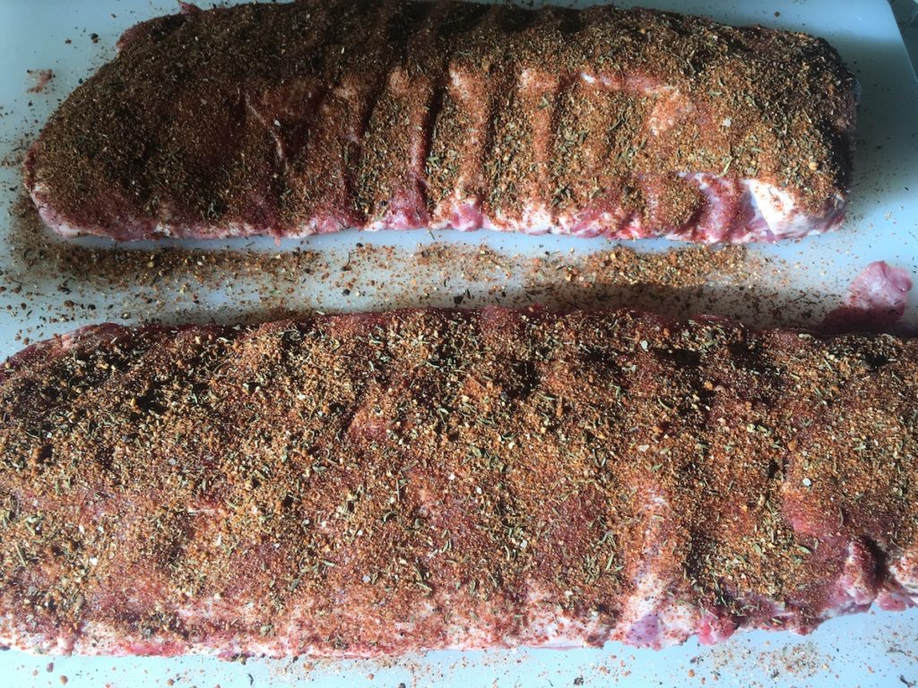 two racks of pork ribs uncooked and covered in spices - best dry rub for ribs